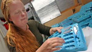Amber Babcock, co-owner of Whisker Works removes plastic mustaches from a mold Thursday, February 5, 2015.  (Red Huber / Orlando Sentinel)